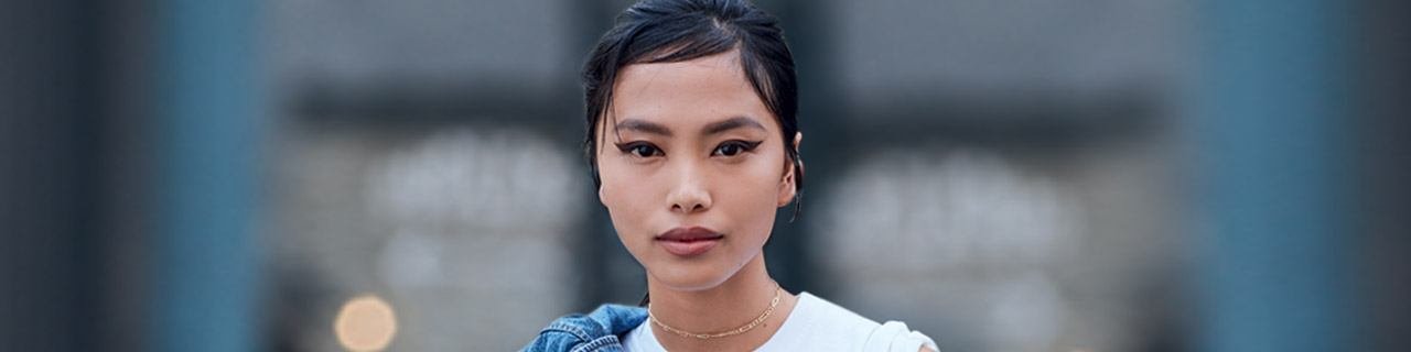 彩妝趨勢說明Banner圖像 - 一位畫了時尚眼線、肩上披著牛仔夾克的女生頭像