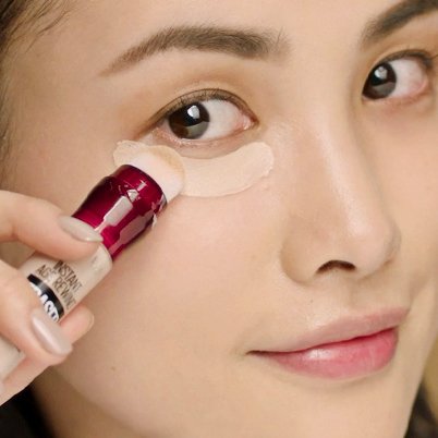 女生在眼部下方塗抹黑眼圈擦擦筆